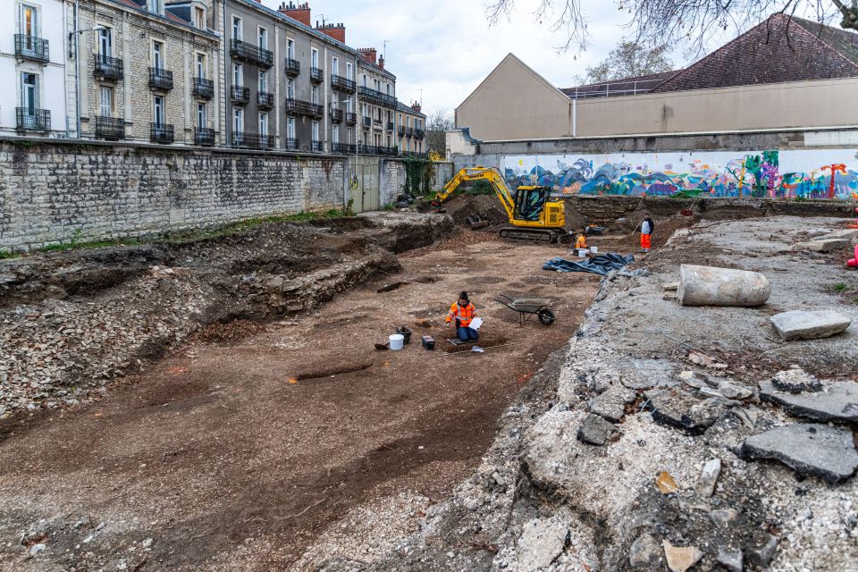 Archaeological dig site with workers excavating.