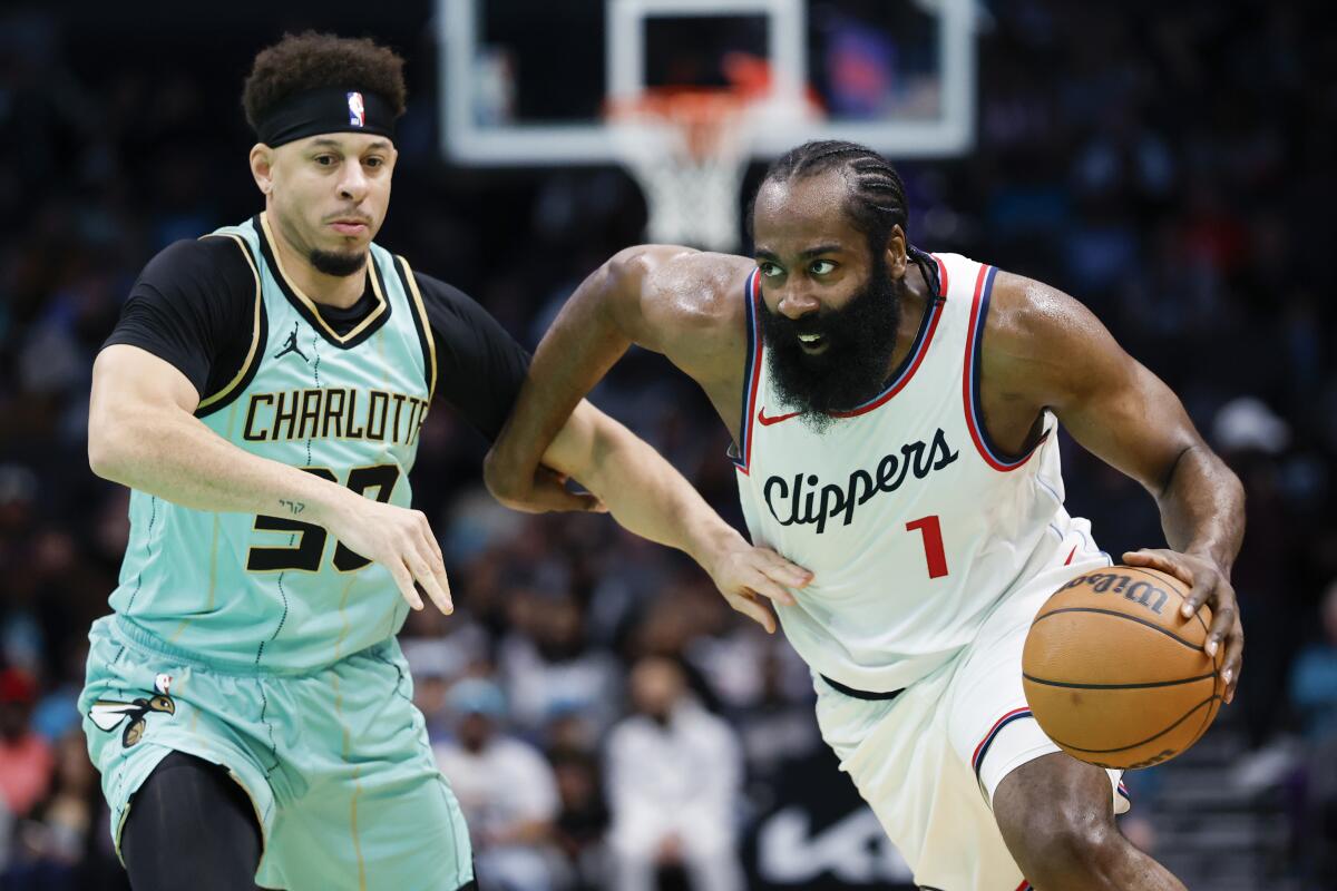 Clippers guard James Harden, right, drives past Hornets guard Seth Curry, left, during the first half Friday night.