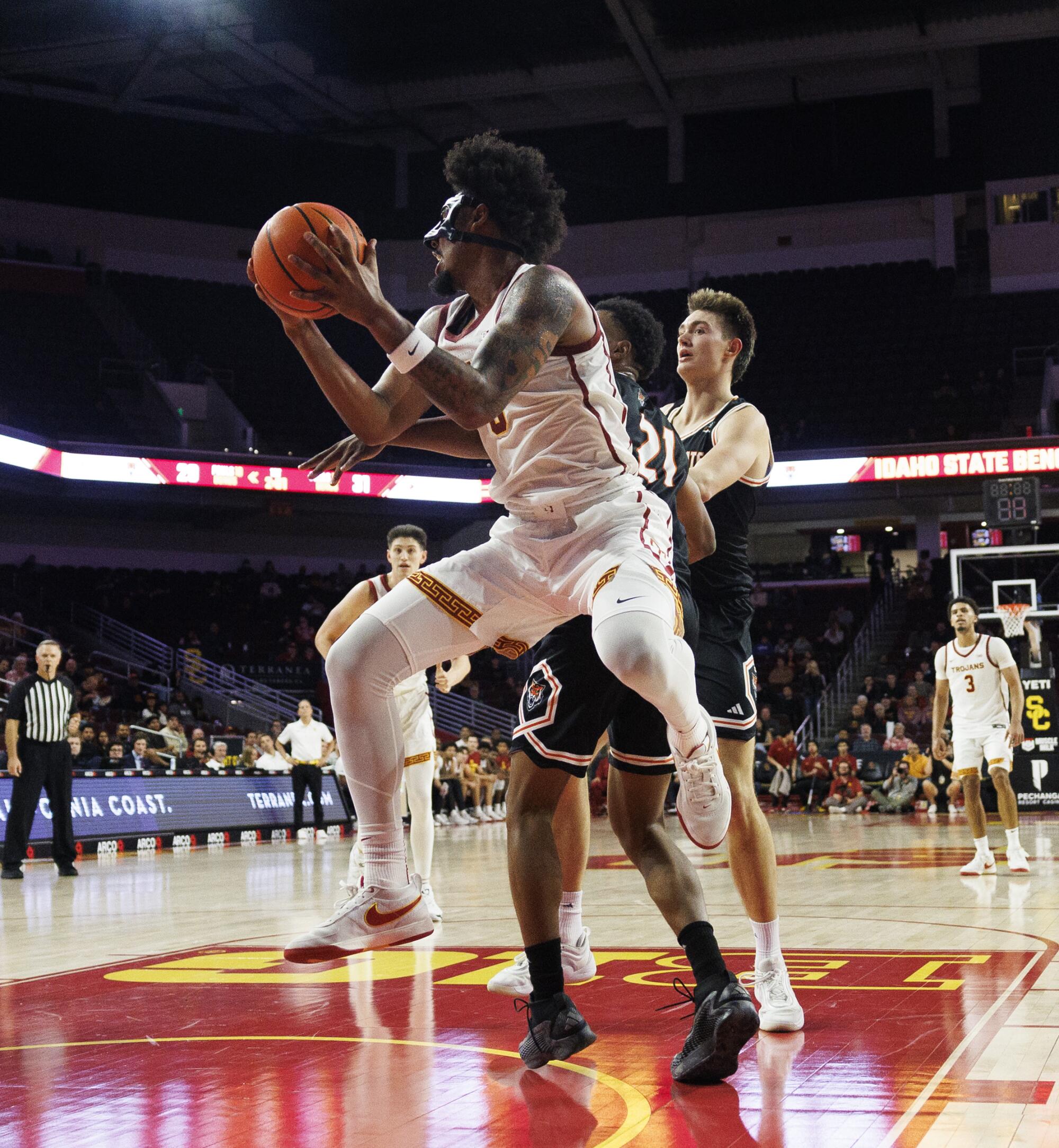 USC forward Saint Thomas grabs a rebound in front of Idaho State forward Jackson Greene on Nov. 7.