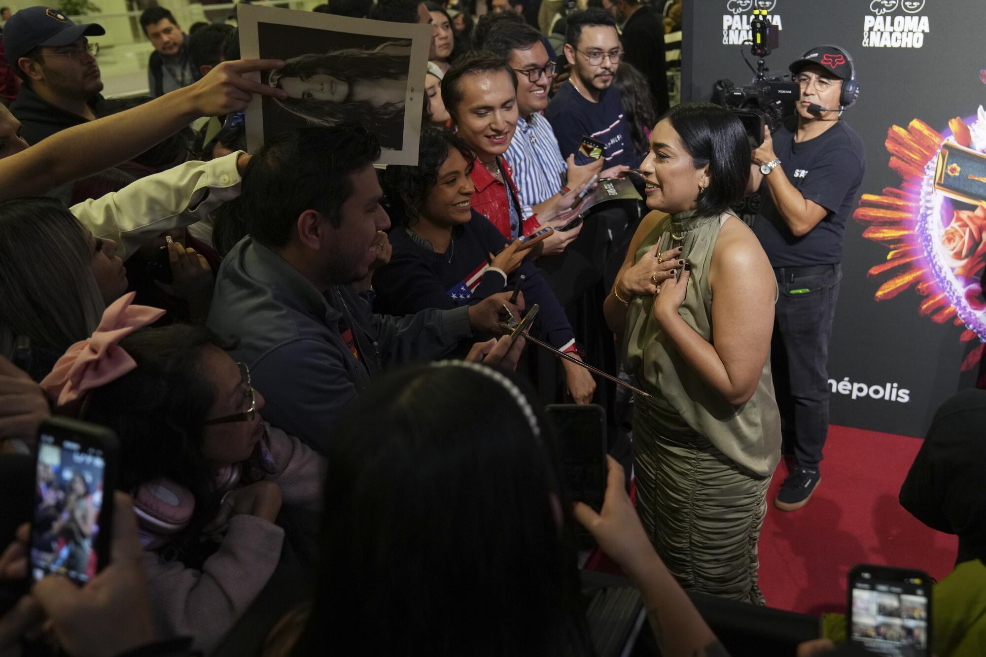 Actress Adriana Paz interacts with fans at a red carpet event