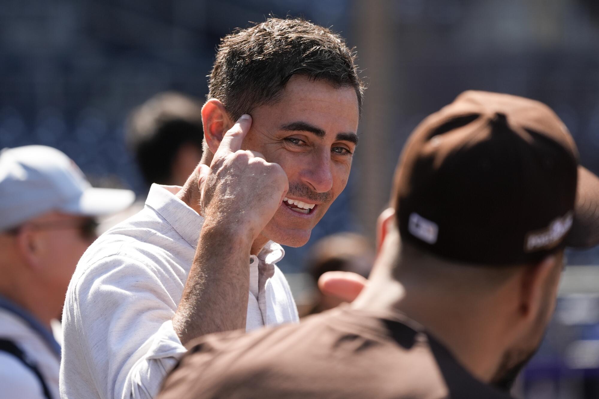 San Diego Padres general manager A.J. Preller gestures and smiles before a wild-card playoff game.