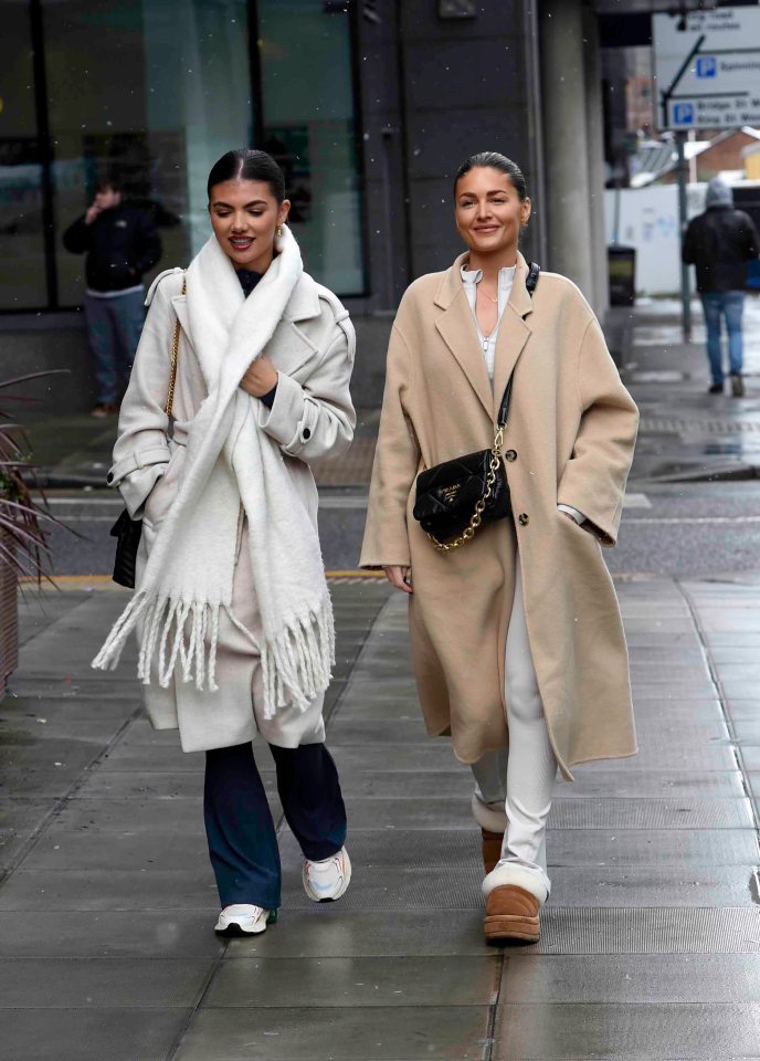 Samie Elishi and Claudia Fogarty walking down a street.