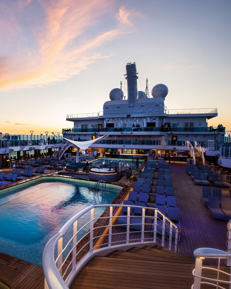 Sky Princess cruise ship pool deck at sunset.