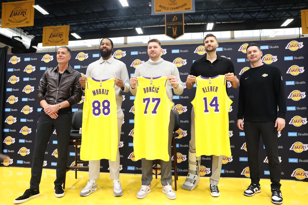 New Lakers Markeiff Morris, Luka Doncic and Maxi Kleber pose with their jerseys flanked by GM Rob Pelinka and coach JJ Redick