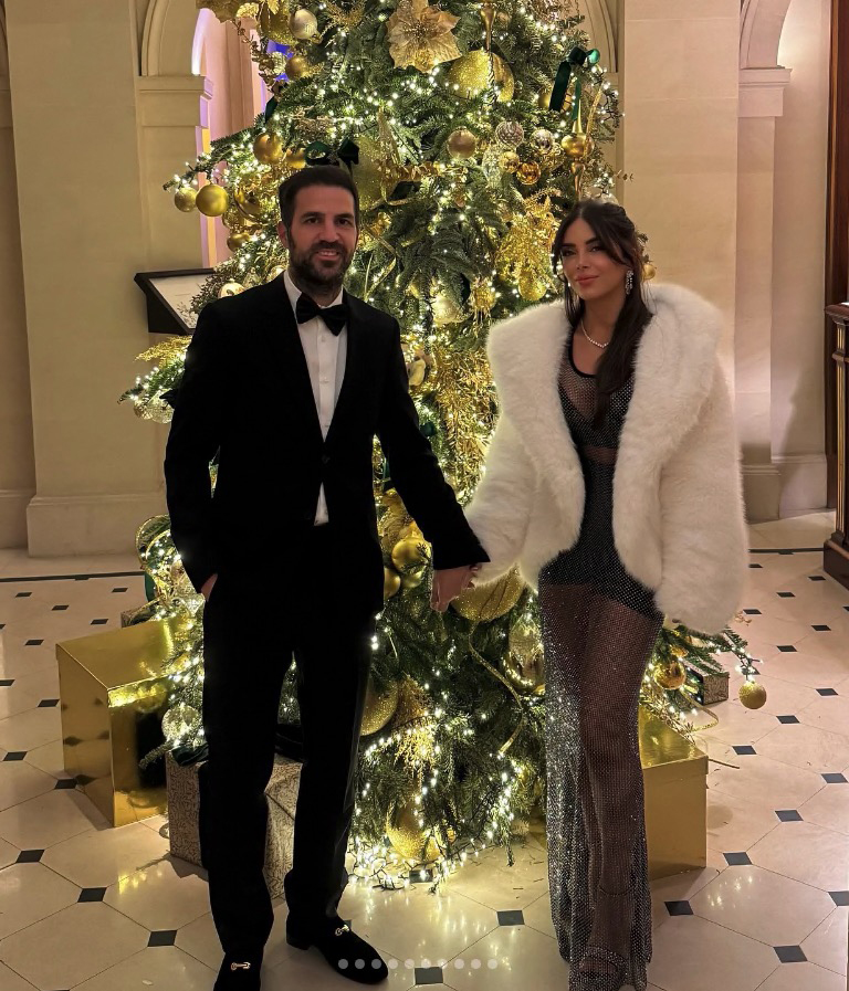 Daniella Semaan and Cesc Fàbregas posing together by a Christmas tree.