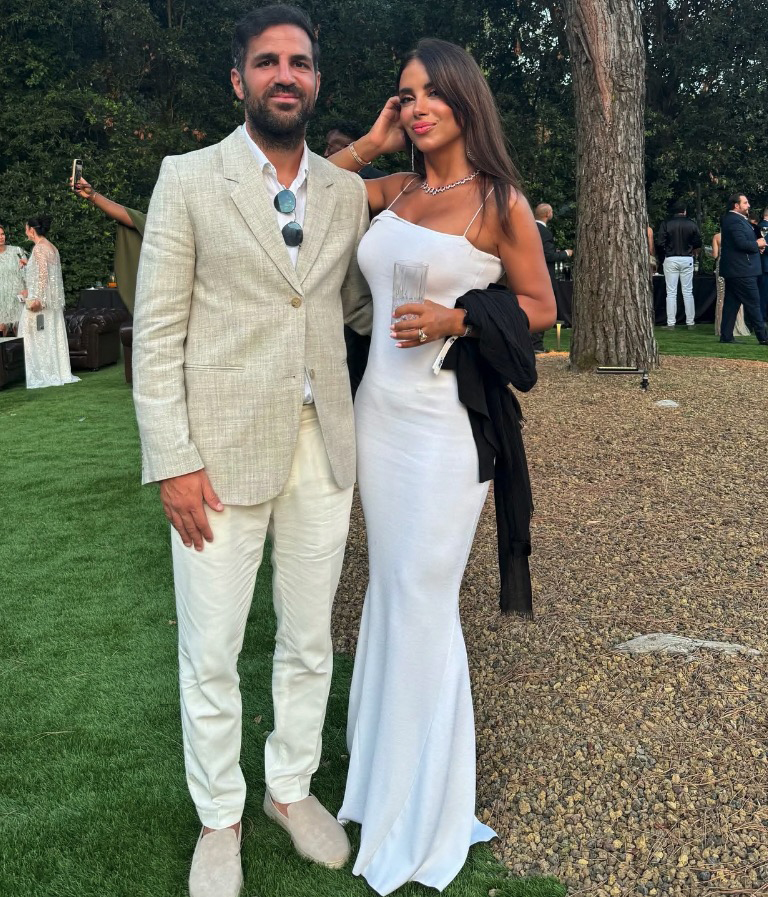 Daniella Semaan and her husband in white formal wear.