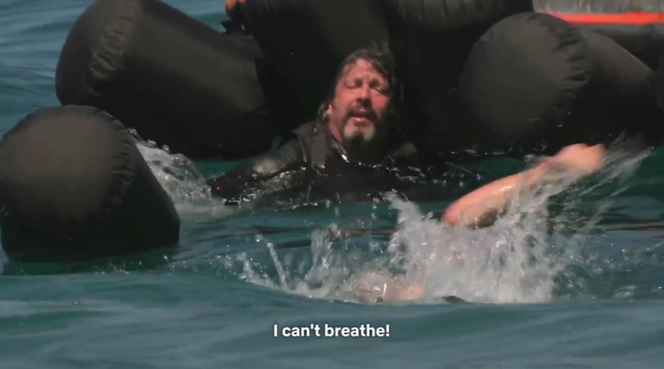 A man struggling in the water, surrounded by flotation devices, says "I can't breathe!"