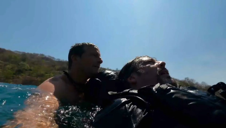 A man rescuing another man from the ocean.