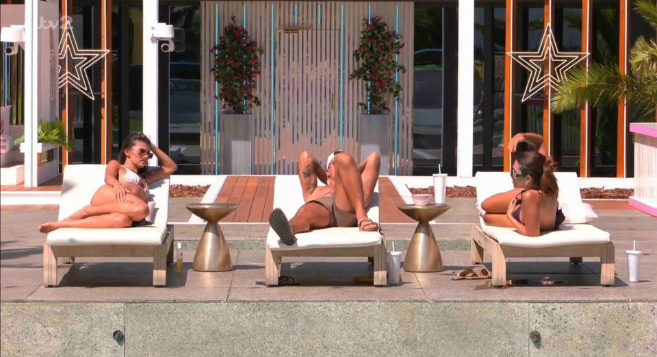 Three people lounging by a pool.