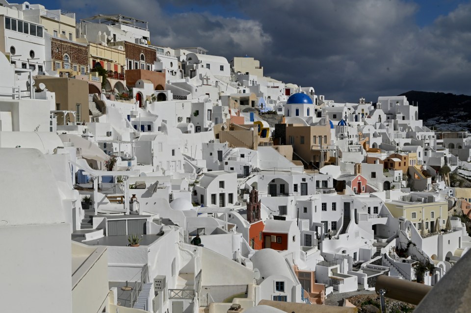 View of Oia, Santorini, Greece, showing whitewashed buildings on a hillside.