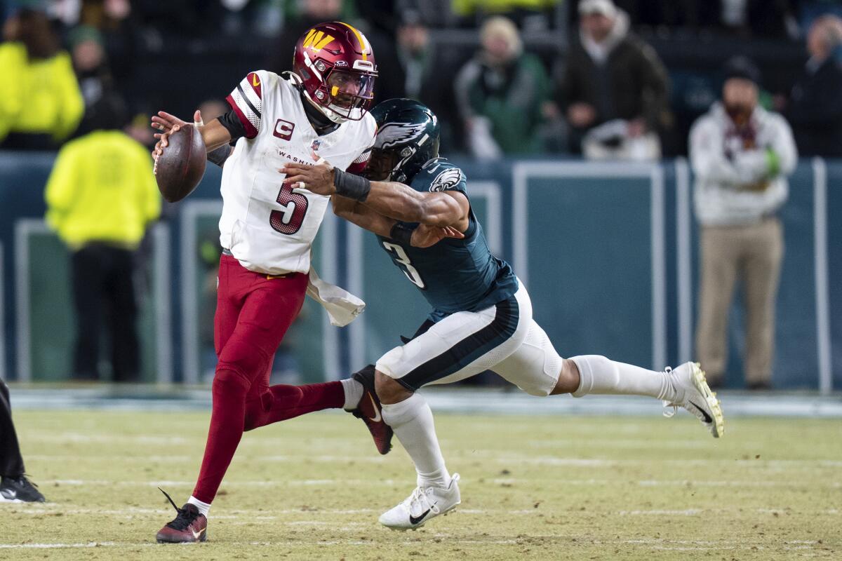 The Commanders' Jayden Daniels (5) is sacked by the Eagles' Nolan Smith Jr.  during the NFL championship game.