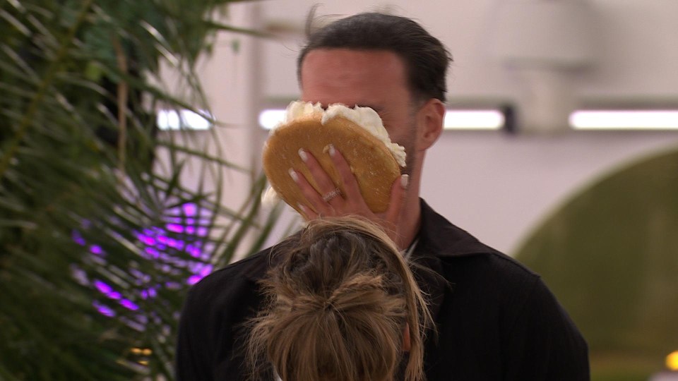 A woman smashing a cake into a man's face.