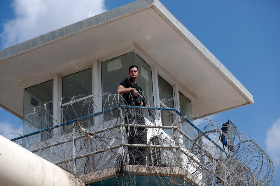 A security guard stands in a prison watchtower.