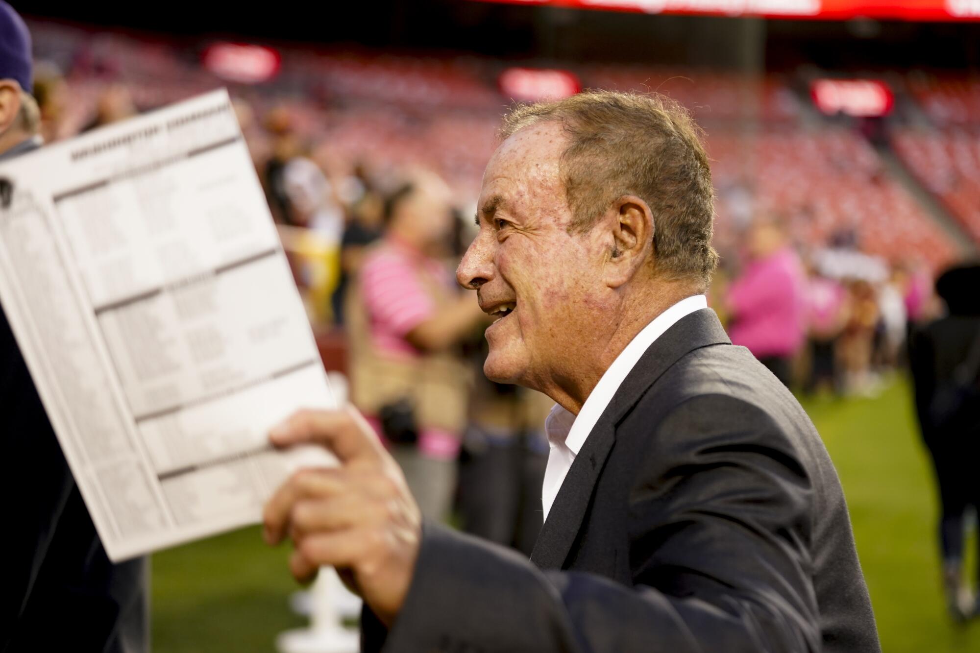 Al Michaels walks on the field before a game between the Washington Commanders and Chicago Bears.