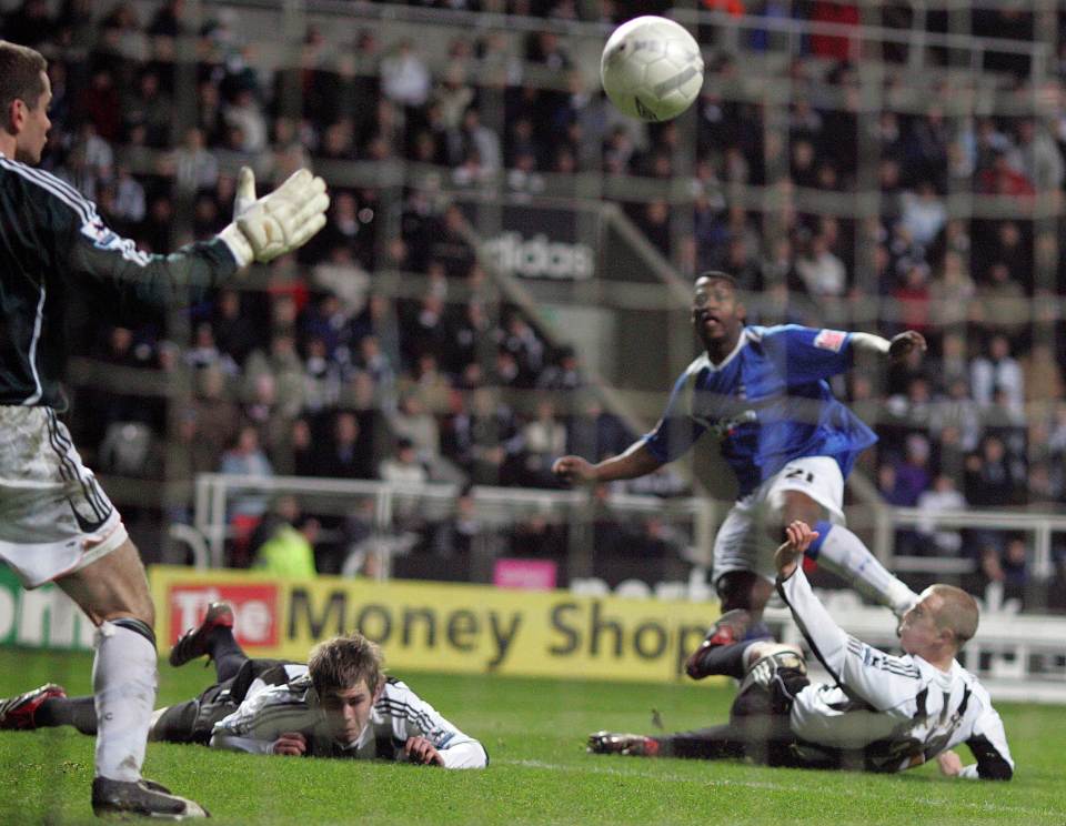 A soccer player scores a goal during a match.