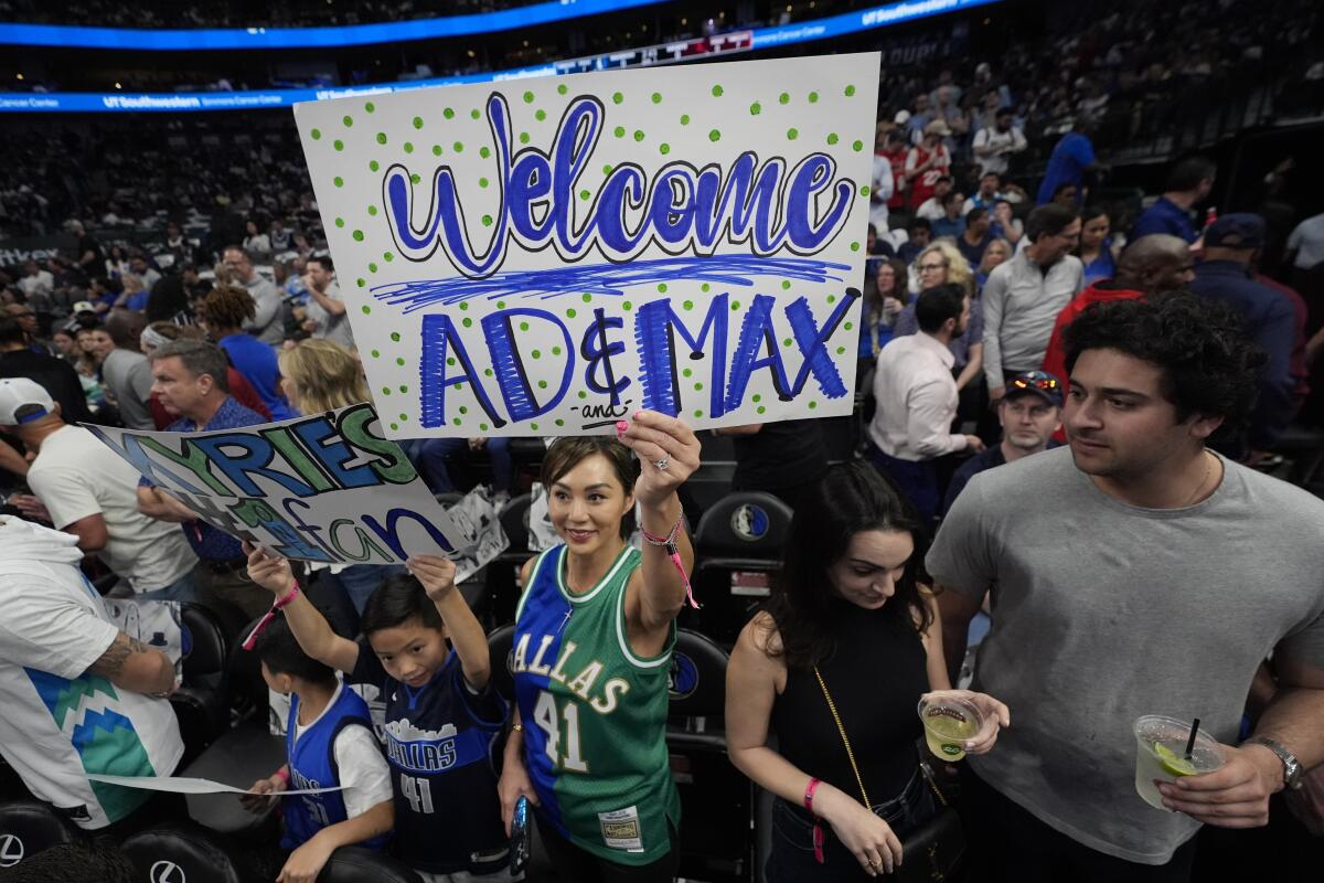 A fan holds up a sign welcoming new Mavericks forward Anthony Davis and guard Max Christie on Saturday.