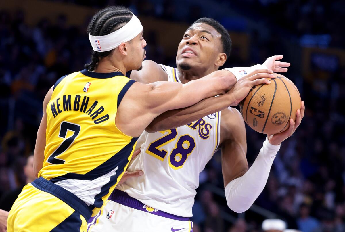 Lakers forward Rui Hachimura is fouled by Pacers guard Andrew Nembhard while trying to power his way to the basket.