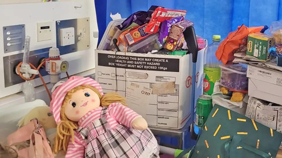 Overfilled box of snacks and a doll.