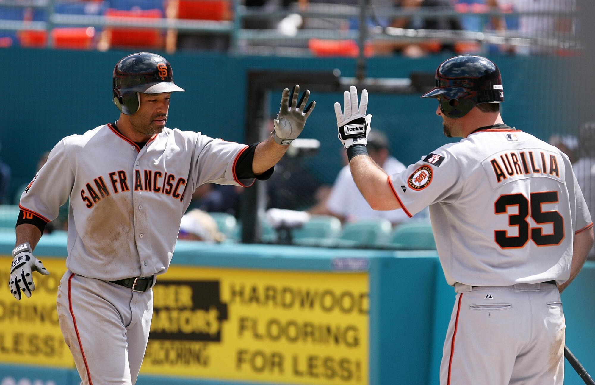 Dave Roberts, left, is congratulated by Rich Aurilia after Roberts scored against the Marlins in a game in 2007.