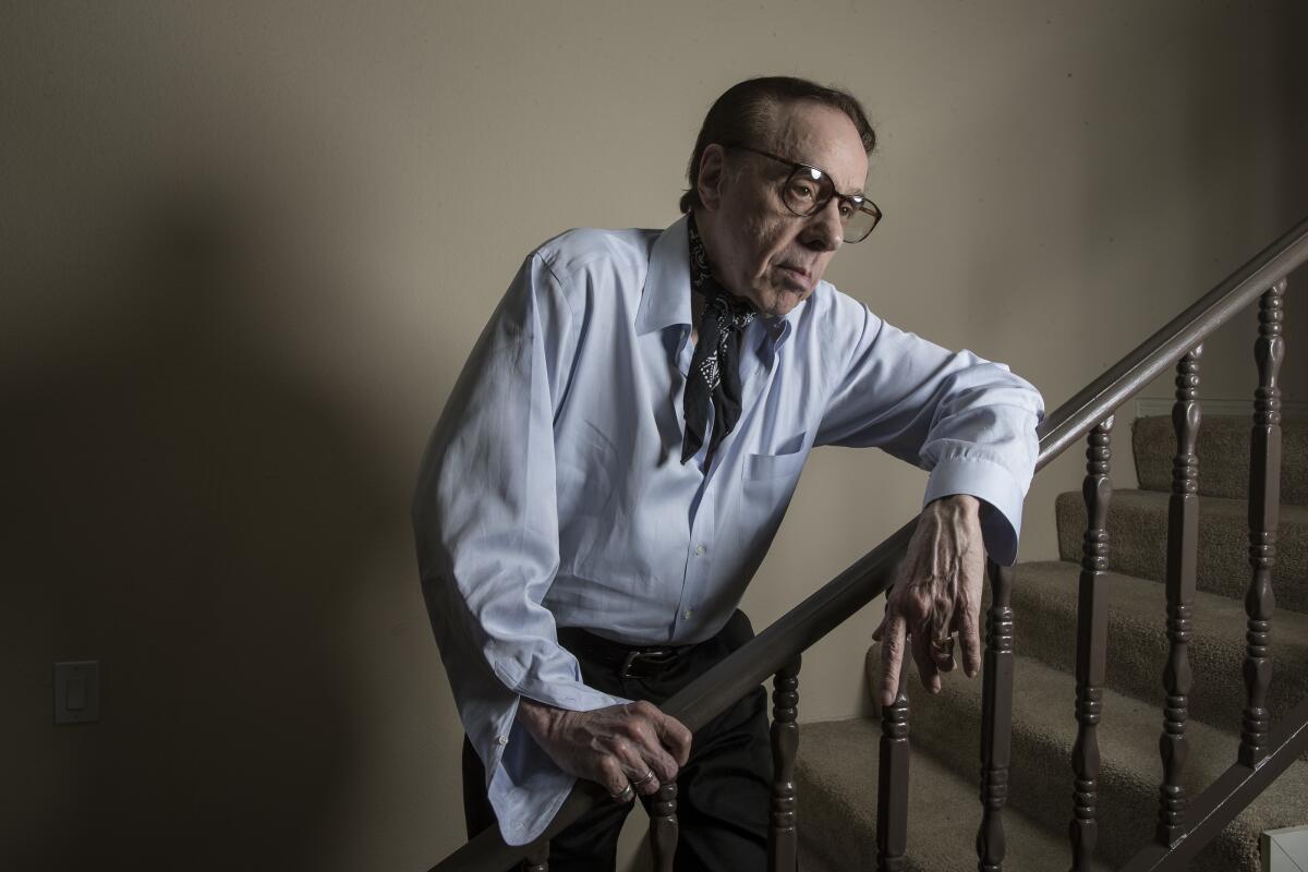 A man poses on a stairwell.