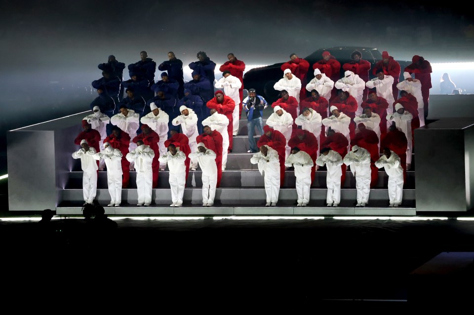 Kendrick Lamar performing onstage with dancers.