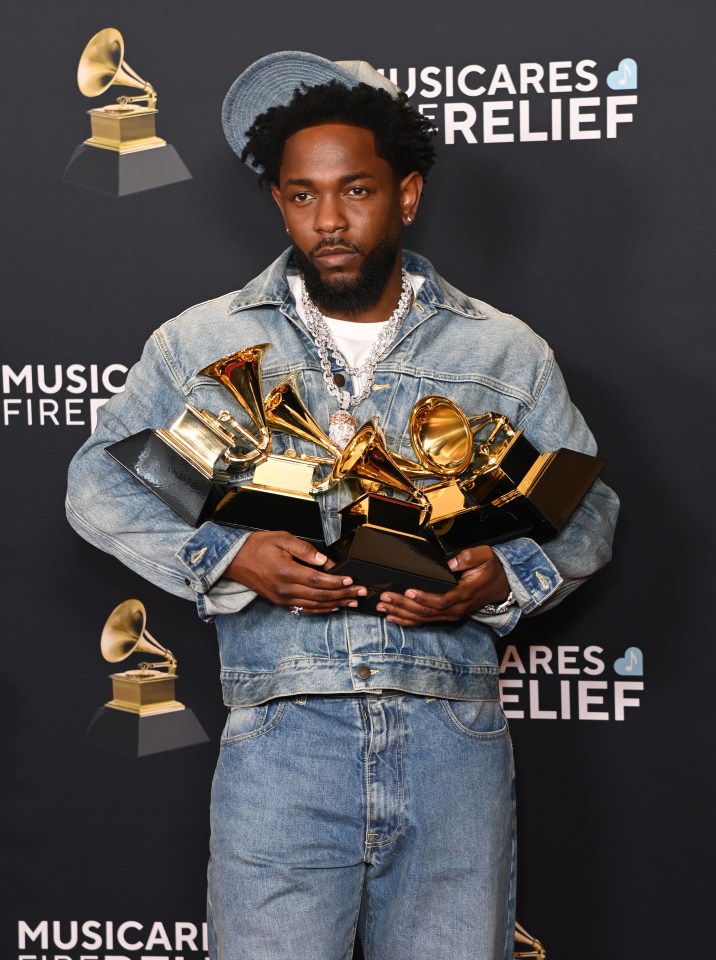 Kendrick Lamar holding multiple Grammy Awards.