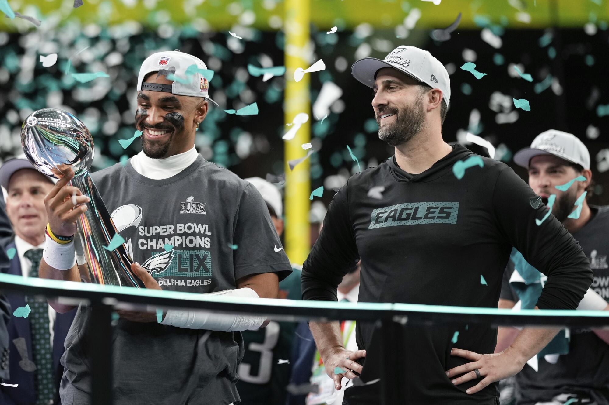 Philadelphia Eagles quarterback Jalen Hurts, left, holds the Vince Lombardi Trophy as he stands next to coach Nick Sirianni.