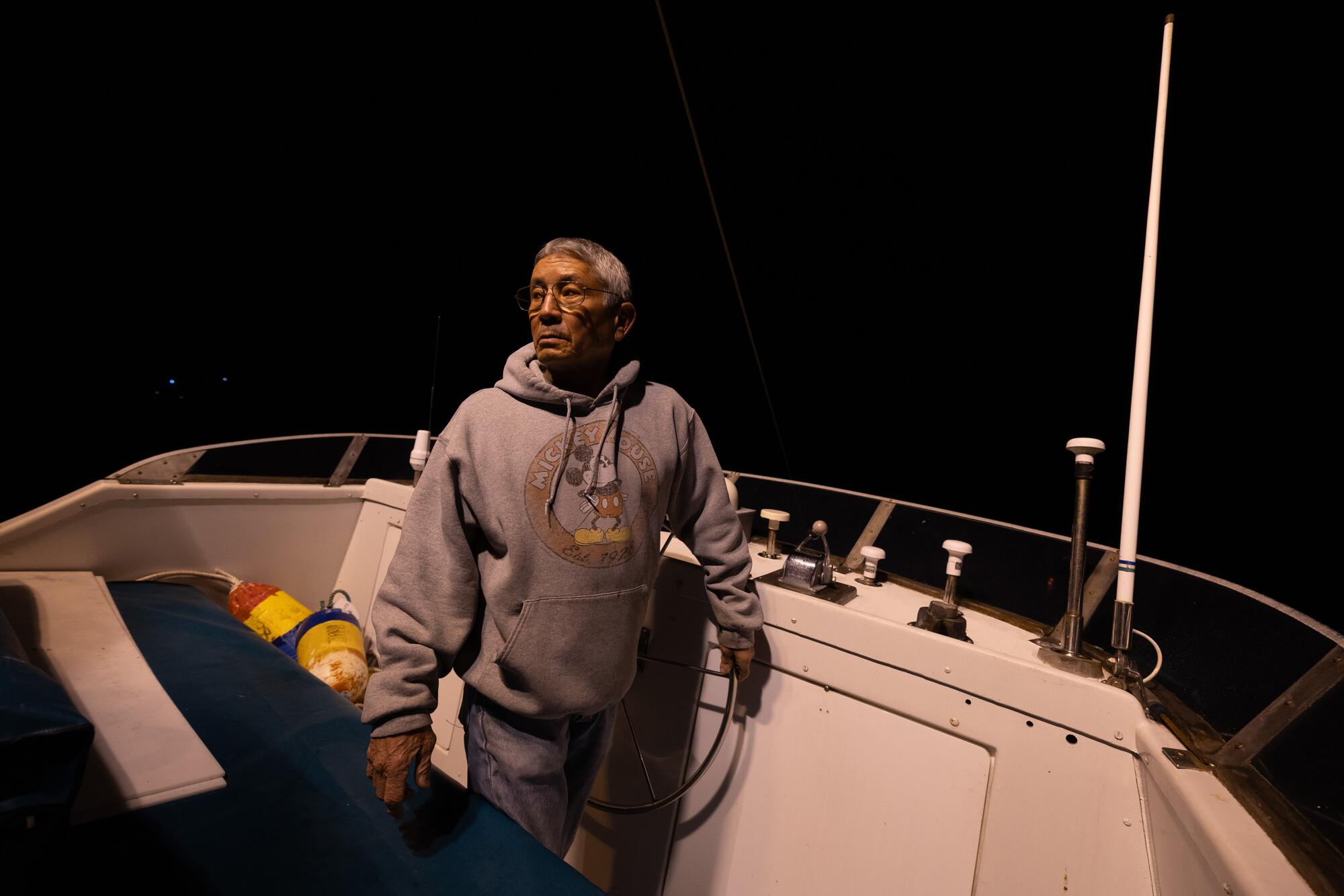 A crab fisherman navigates his boat out of port in the pre-dawn hours. 