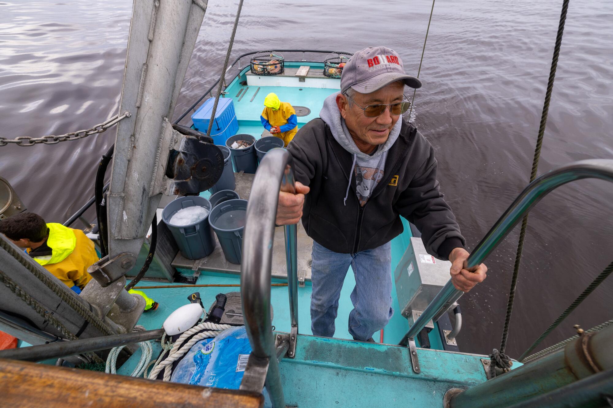 A boat captain climbs a ladder to the flybridge.