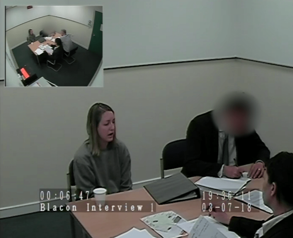 Screenshot of a police interview, showing a woman being interviewed while others sit at a table.