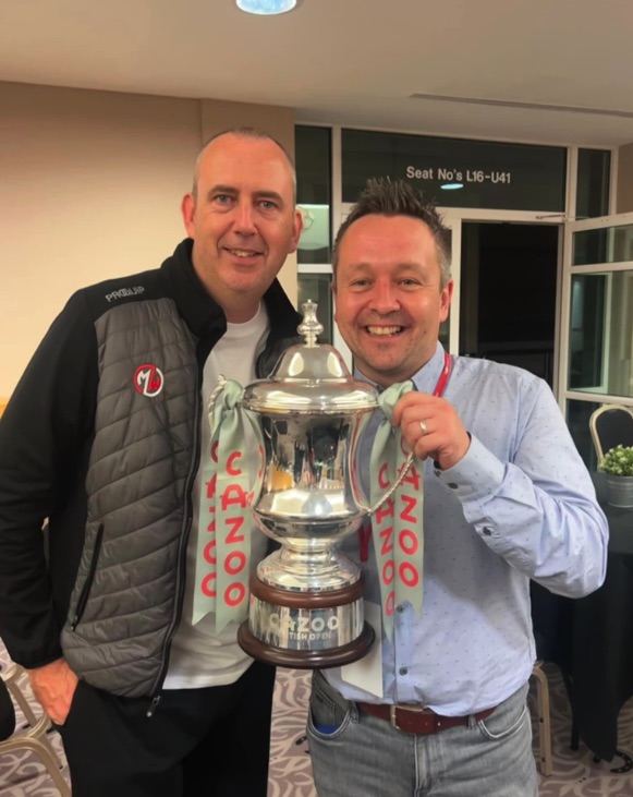 Two men holding a trophy.