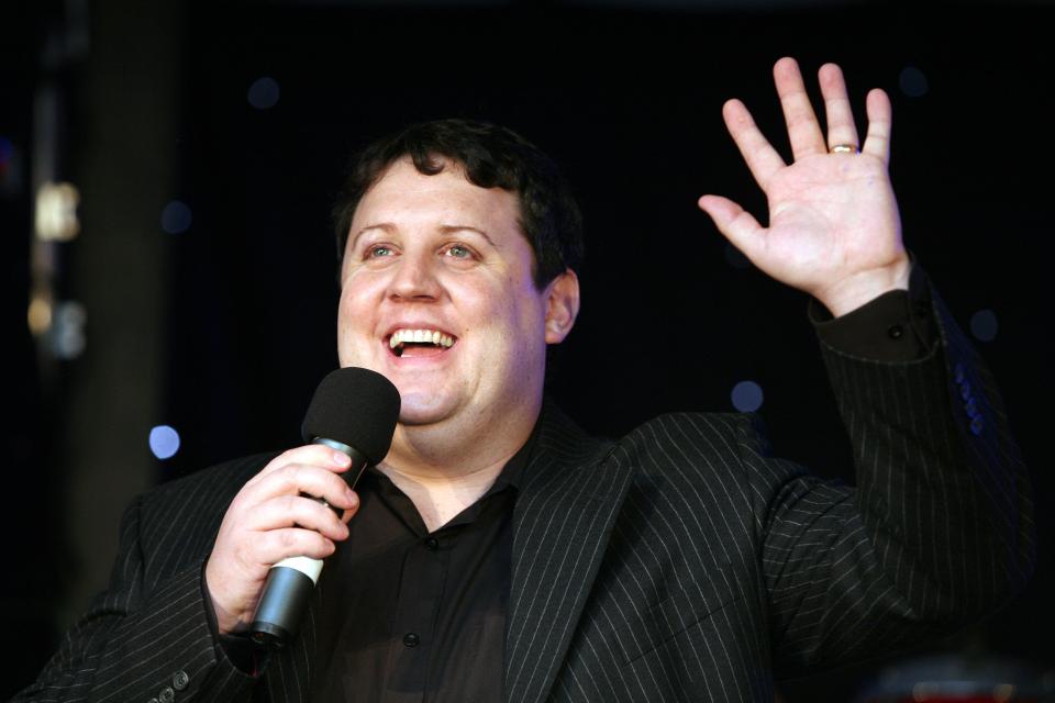 Peter Kay speaking into a microphone at a charity event.