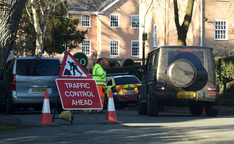 Traffic control ahead sign and vehicles on a residential street.