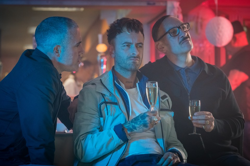 Three men sitting together, drinking champagne.