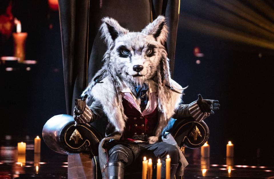 Wolf costume from The Masked Singer sitting on a throne.