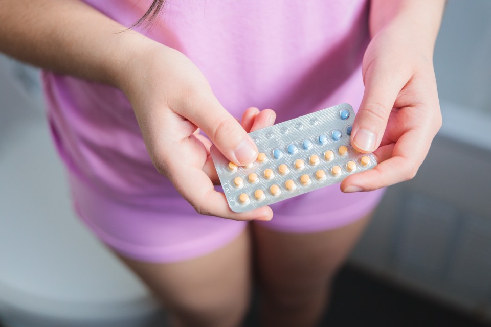 Woman holding birth control pills.