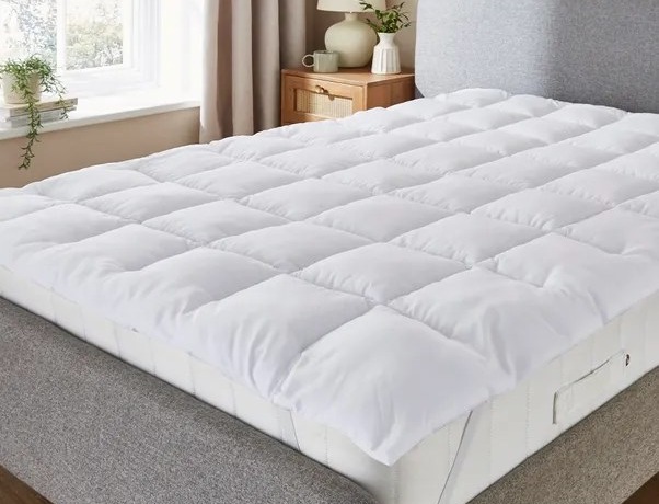 White mattress topper on a bed.