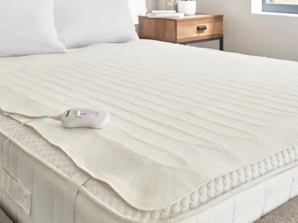 Electric heated mattress pad on a bed.