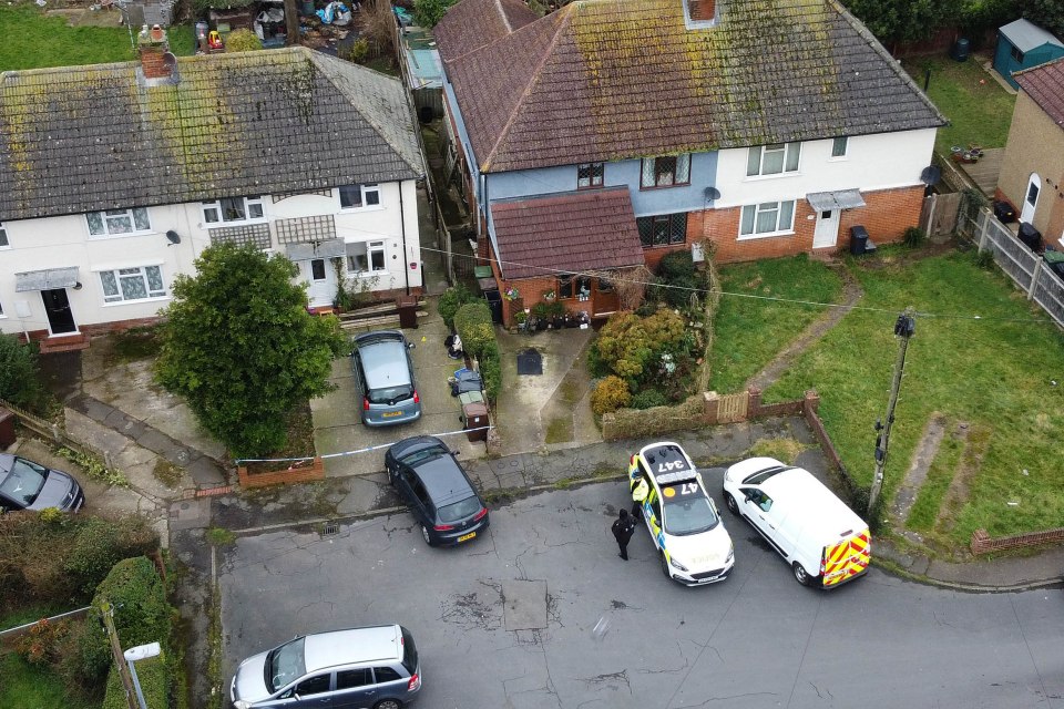 Aerial view of a crime scene with police cars and a house.