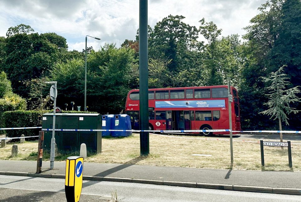 Police tape at a bus stop near a red double-decker bus.