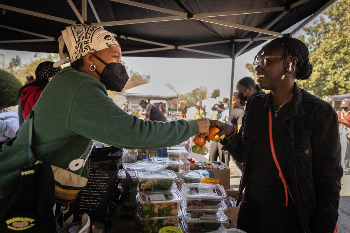 Community members exchange fist bumps over packaged meals at a donation center