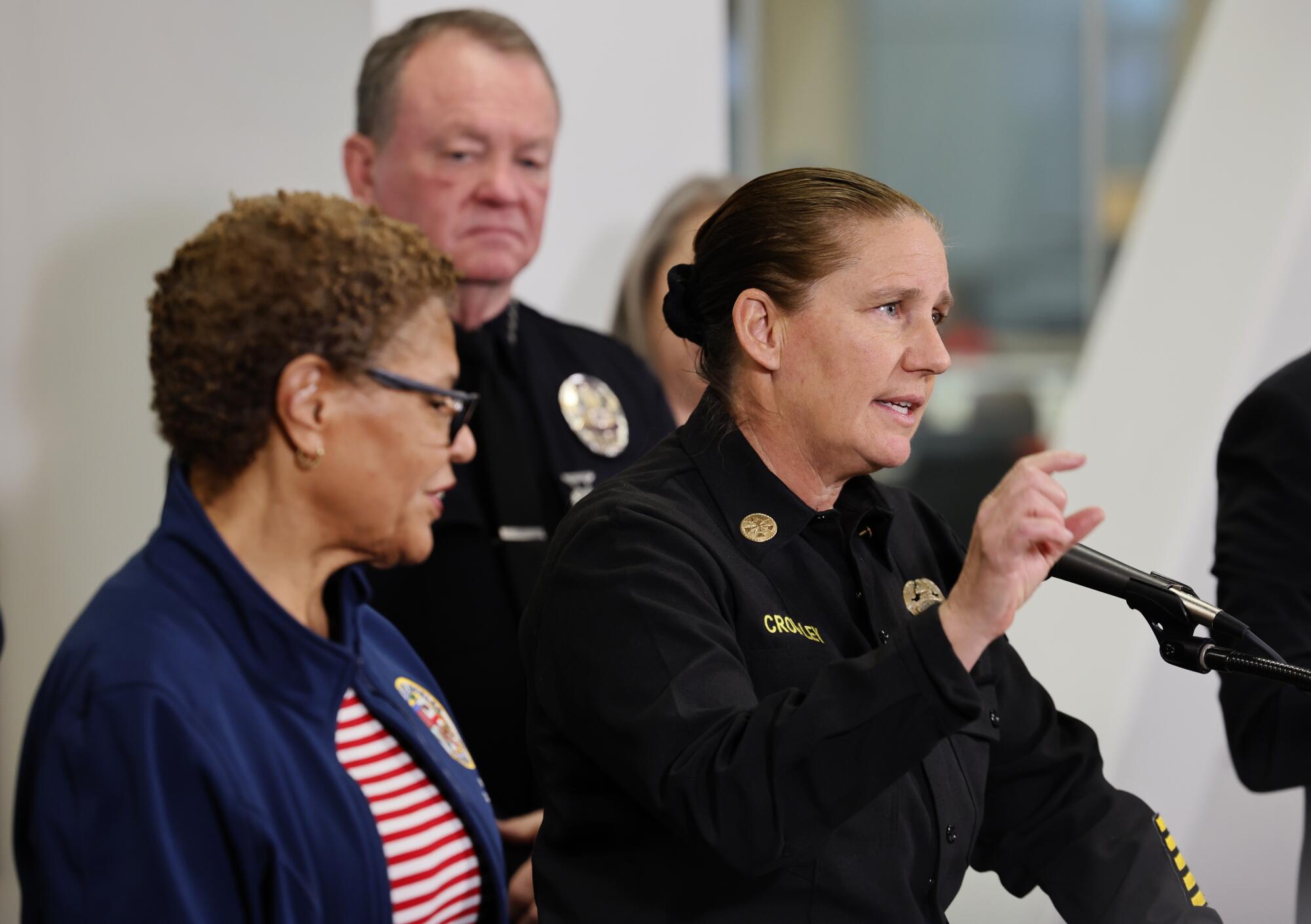 Mayor Karen Bass, left, L.A. Fire Chief Kristin Crowley, right, and LAPD Chief Jim McDonnell, rear, at a news conference.