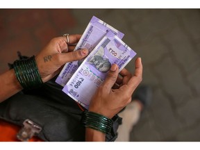 An employee holds one hundred Indian rupee banknotes for photograph at an Indian Oil Corp. gas station in Mumbai, India, on Wednesday, Jan 3, 2024. Photographer: Dhiraj Singh/Bloomberg