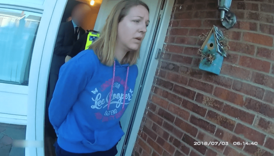 A woman in handcuffs being arrested by a police officer.