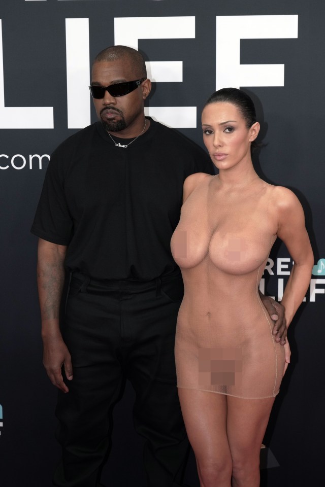 Kanye West and a woman in a sheer dress at an event.