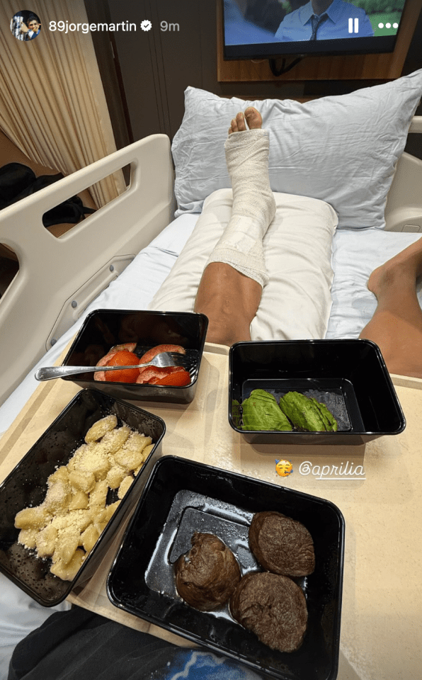 Person with leg in cast in hospital bed with meal tray.