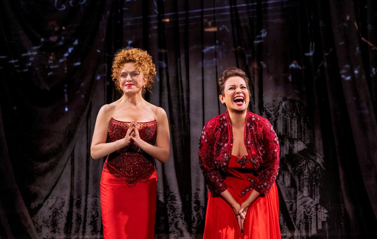 Bernadette Peters and Lea Salonga, in red dresses, bow onstage