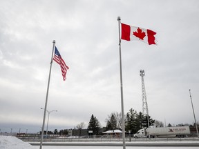 The Canadian and United States flags fly near the border in Blackpool, Que.