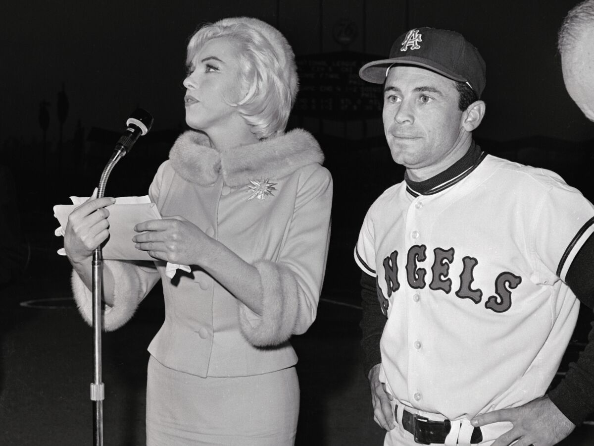 (Original Caption) Actress Marilyn Monroe runs into the field at Chavez Ravine accompanied by Los Angeles Angel