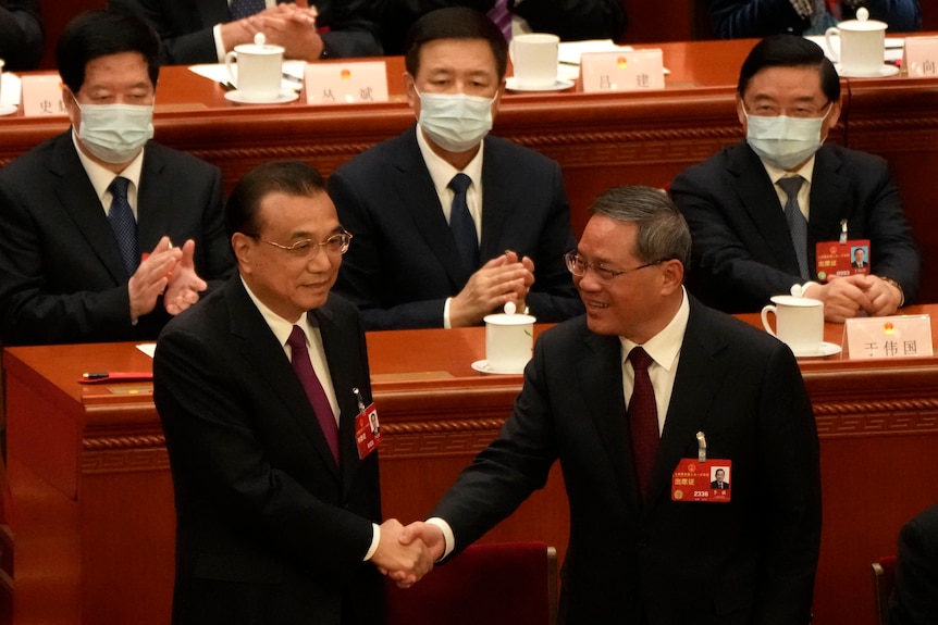 Li Qiang (left) shakes hands with Li Keqiang.